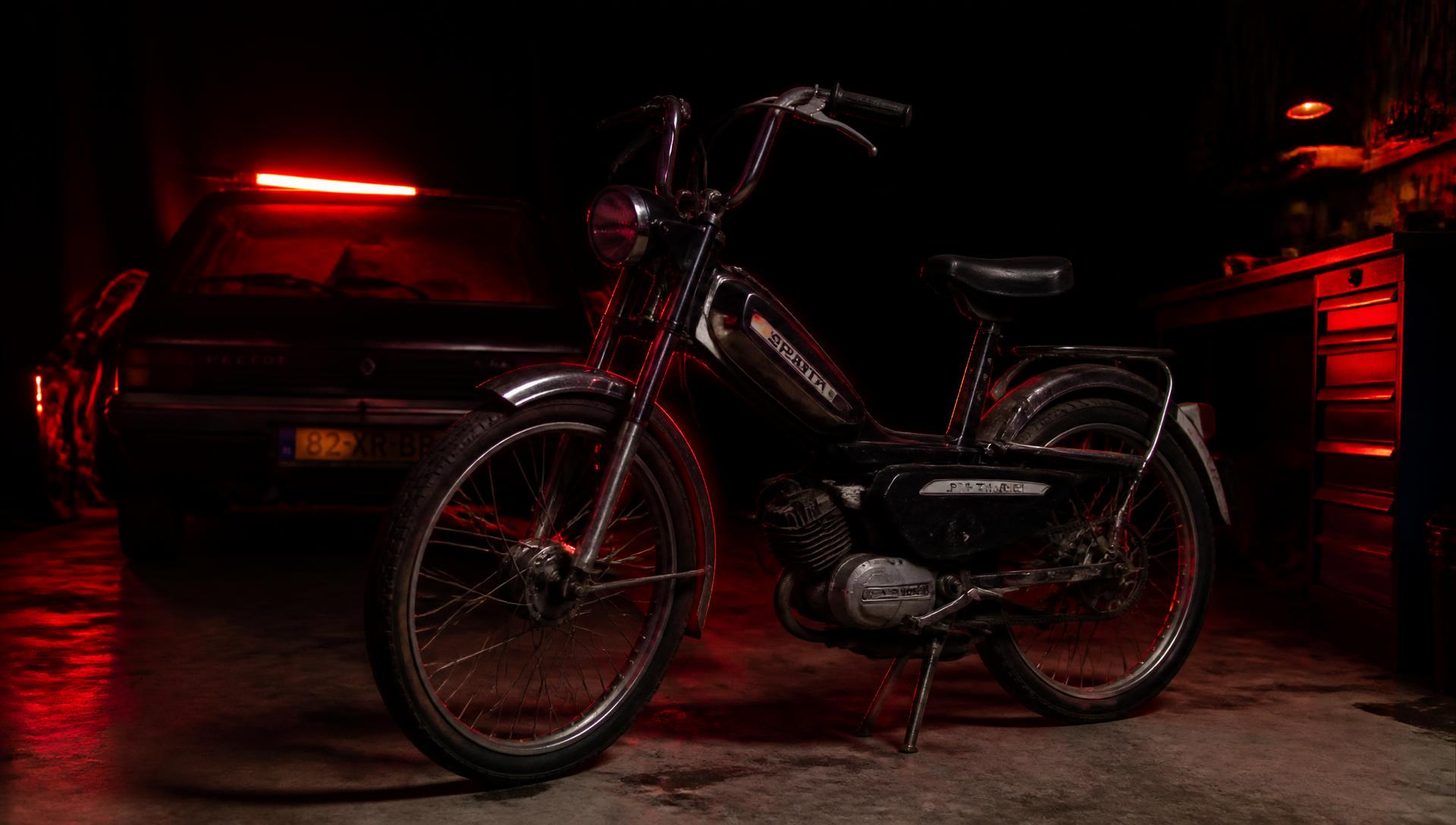Spartamet en auto in een donkere garage met rood licht